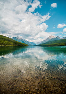 photo of calmed body of water near mountain thumbnail