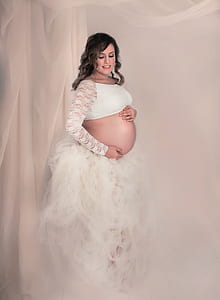 pregnant woman wearing white crop-top and ruffled skirt thumbnail