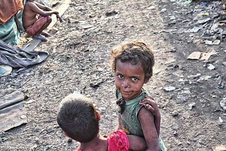 two children standing beside man sitting thumbnail