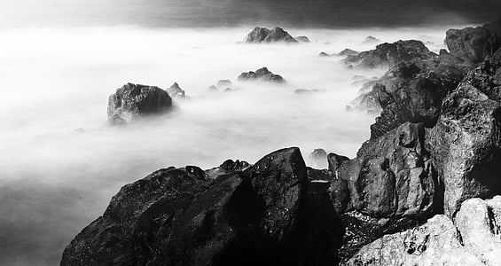 grayscale photo of mountain cliff and sea of clouds thumbnail