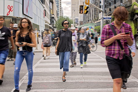 people walking across pedestrian lane during daytime thumbnail