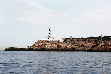 lighthouse under cloudy sky thumbnail