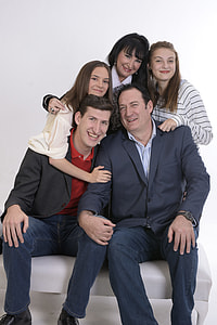 two man sitting on white leather sofa bench with three woman holding photo thumbnail