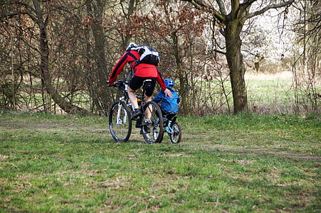 man riding bike while guiding boy riding bike taken at daytime thumbnail