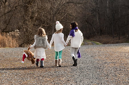 three girls walking near trees during daytime thumbnail