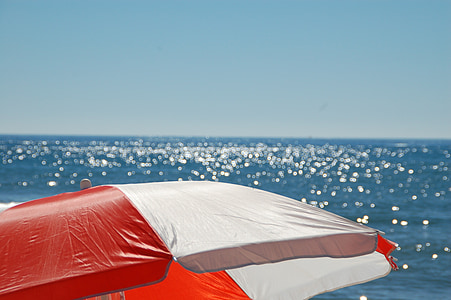 white and red patio umbrella facing horizon thumbnail