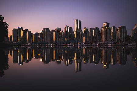 reflective photography of cityscape by water thumbnail