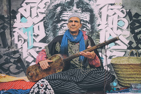photo of man playing string instrument at street thumbnail