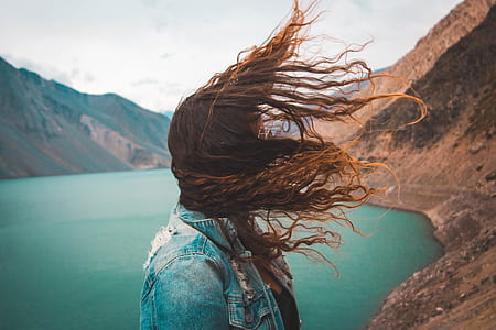 time lapse photography of woman covered with her hair near the lake thumbnail