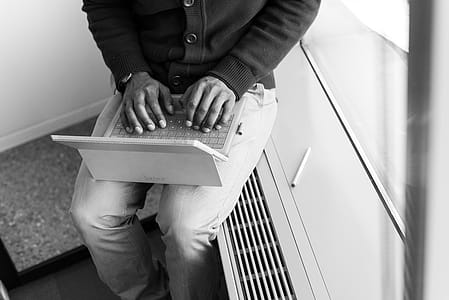 Greyscale Photo of Man Using Laptop Computer thumbnail