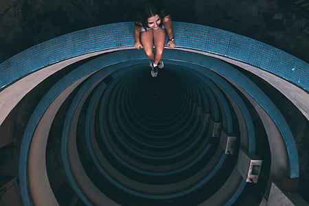 top view photography of woman sitting on edge of building thumbnail