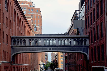 empty bridge connecting two red concrete buildings during daytime thumbnail