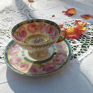 white-blue-and-pink floral teacup and saucer surrounded by petaled flowers thumbnail
