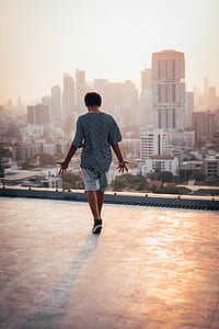 man standing out top of high-rise building thumbnail