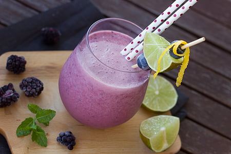 round drinking glass with fruit shake juice and two sliced lemons thumbnail