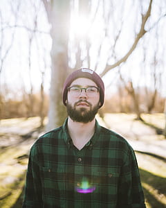 man wearing eyeglasses in front of brown tree during daytime thumbnail
