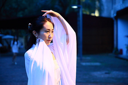 woman wearing white dress and standing outdoors thumbnail
