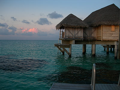 floating cottage on calm body of water thumbnail