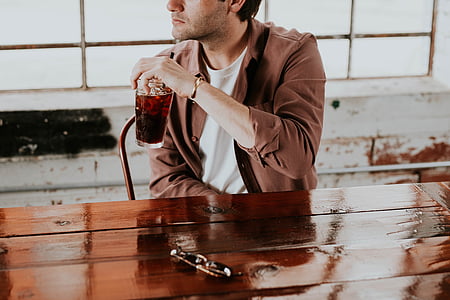 man in brown collared shirt sitting beside table thumbnail