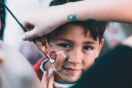 person doing face painting of boy's cheek thumbnail