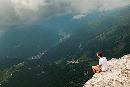 man sitting beside cliff thumbnail