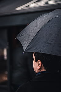 man holding black umbrella thumbnail