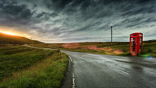 red telephone booth beside road thumbnail