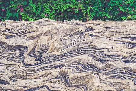 nature photography of folding rock beside green plants at daytime thumbnail