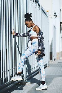Woman Wearing White and Blue Pants and Pair of Gray-and-white Low-top Sneakers thumbnail