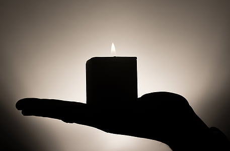 person holding lighted candle thumbnail
