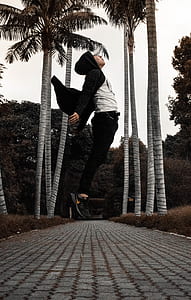 man jumping on pathway during daytime thumbnail