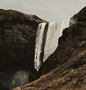 waterfalls near brown rocky mountain thumbnail