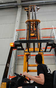 man riding forklift near scaffolding inside gray building thumbnail