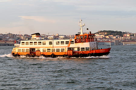 white and red ferry boat traveling on body of water thumbnail