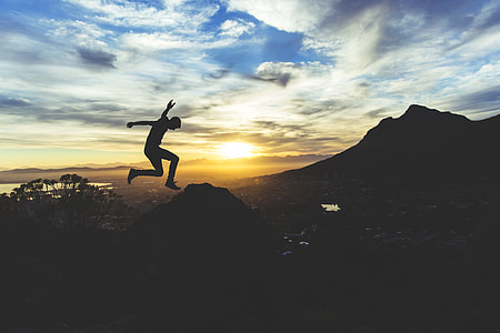 silhouette of a human jumping on the mountain thumbnail
