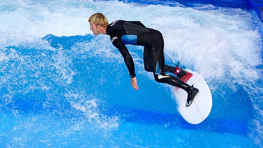 man wearing suit and surfing on body of water thumbnail