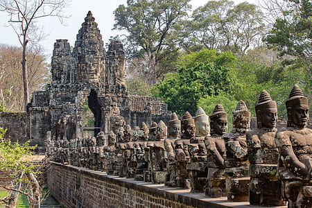 piled statues beside trees thumbnail
