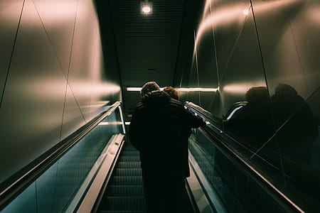 Person in Black Jacket Standing on Escalator thumbnail