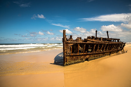 brown ship wreck near shoreline during daytime thumbnail