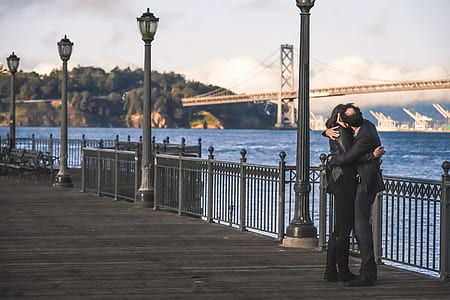 man and woman kissing beside fence thumbnail
