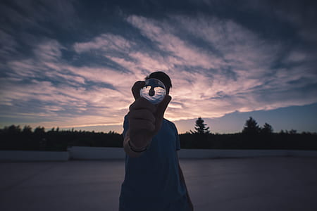 fish eye photography of man holding clear crystal ball thumbnail