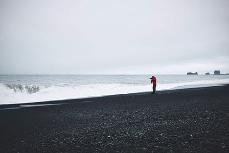 Person in Red Top Standing Near Body of Water thumbnail