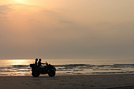 two persons riding ATV on seashore thumbnail