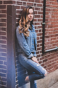 woman in blue denim jacket leaning on wall thumbnail