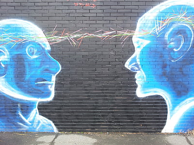 mural of two blue people with linked head on black wall thumbnail