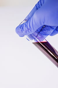 person holding glass bottle with red liquid thumbnail