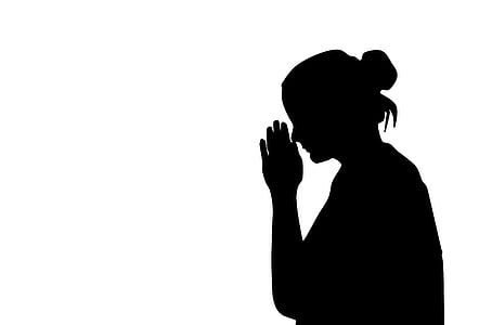 silhouette of woman with her hands together in front of her face thumbnail