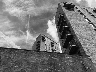 grayscale photography of buildings under cloudy sky during daytime thumbnail