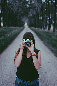 woman in black sleeveless top holding grey bridge camera at daytime thumbnail