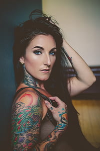 woman holding black top leaning on gray wall thumbnail